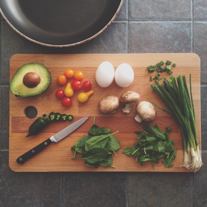 Chef actively plating a dish in a professional kitchen